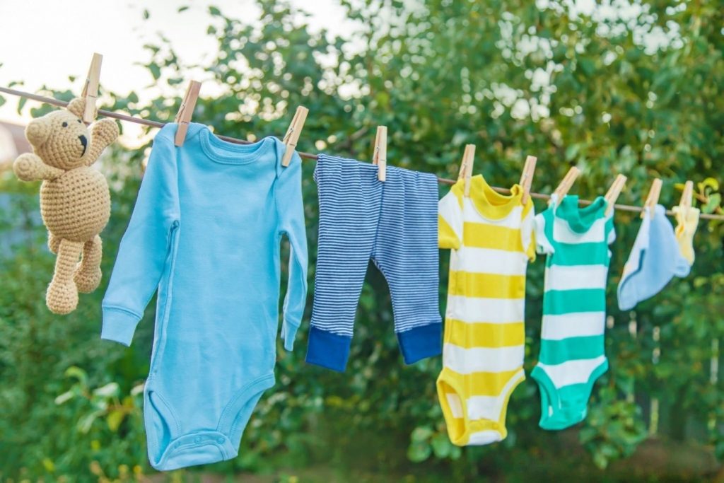 لباس های نوزادی آویزان شده بر روی بند